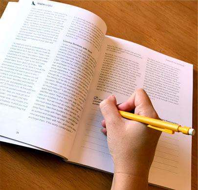 Person Writing in Book